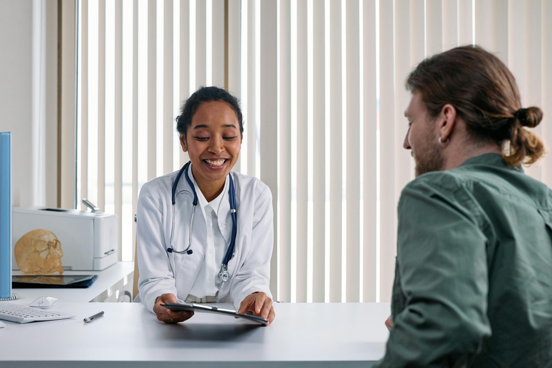 Ein Arzt und ein Patient führen eine positive Beratung in einer hellen Klinikumgebung.